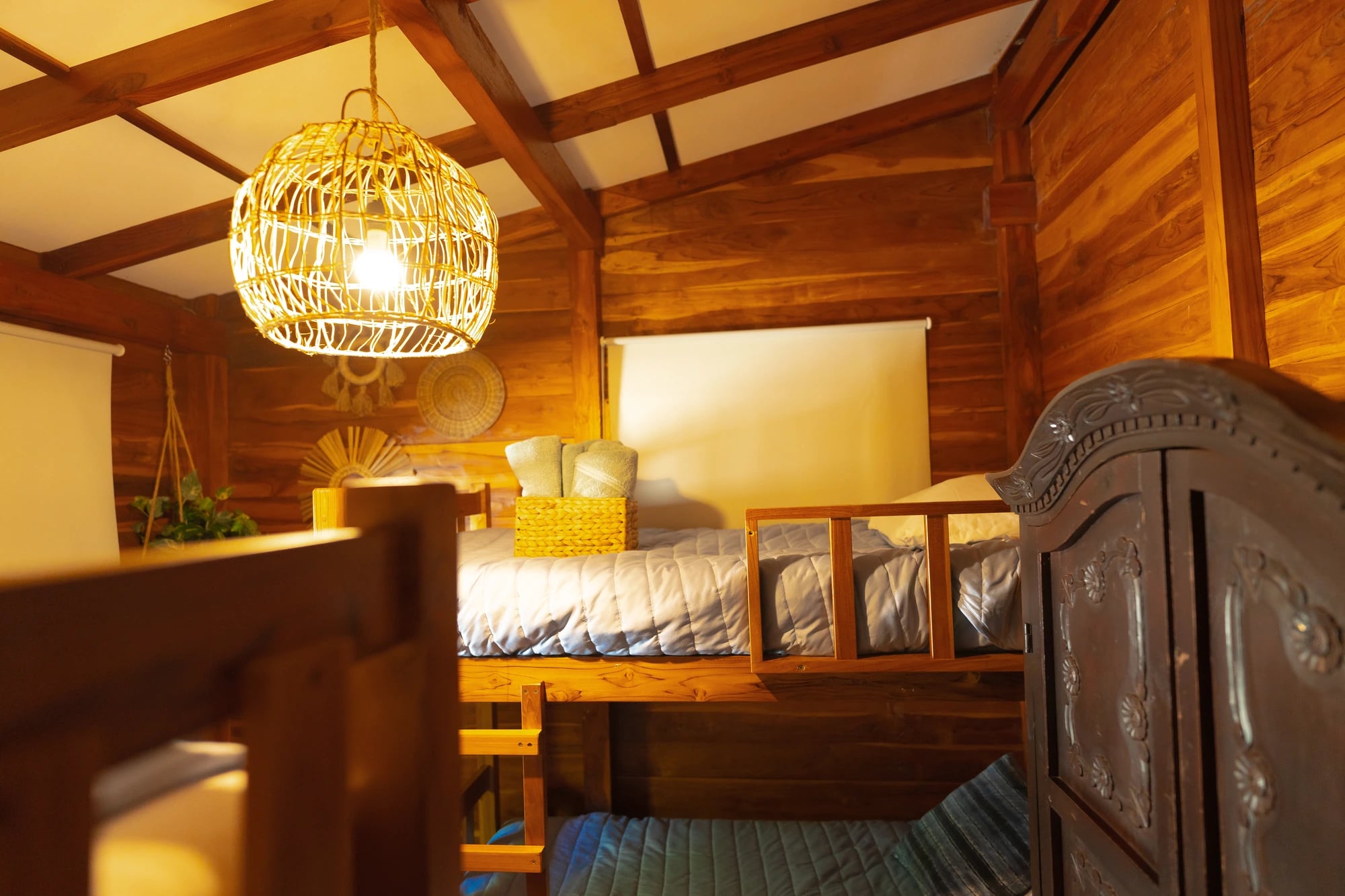 Habitación con literas iluminada por una lámpara tejida